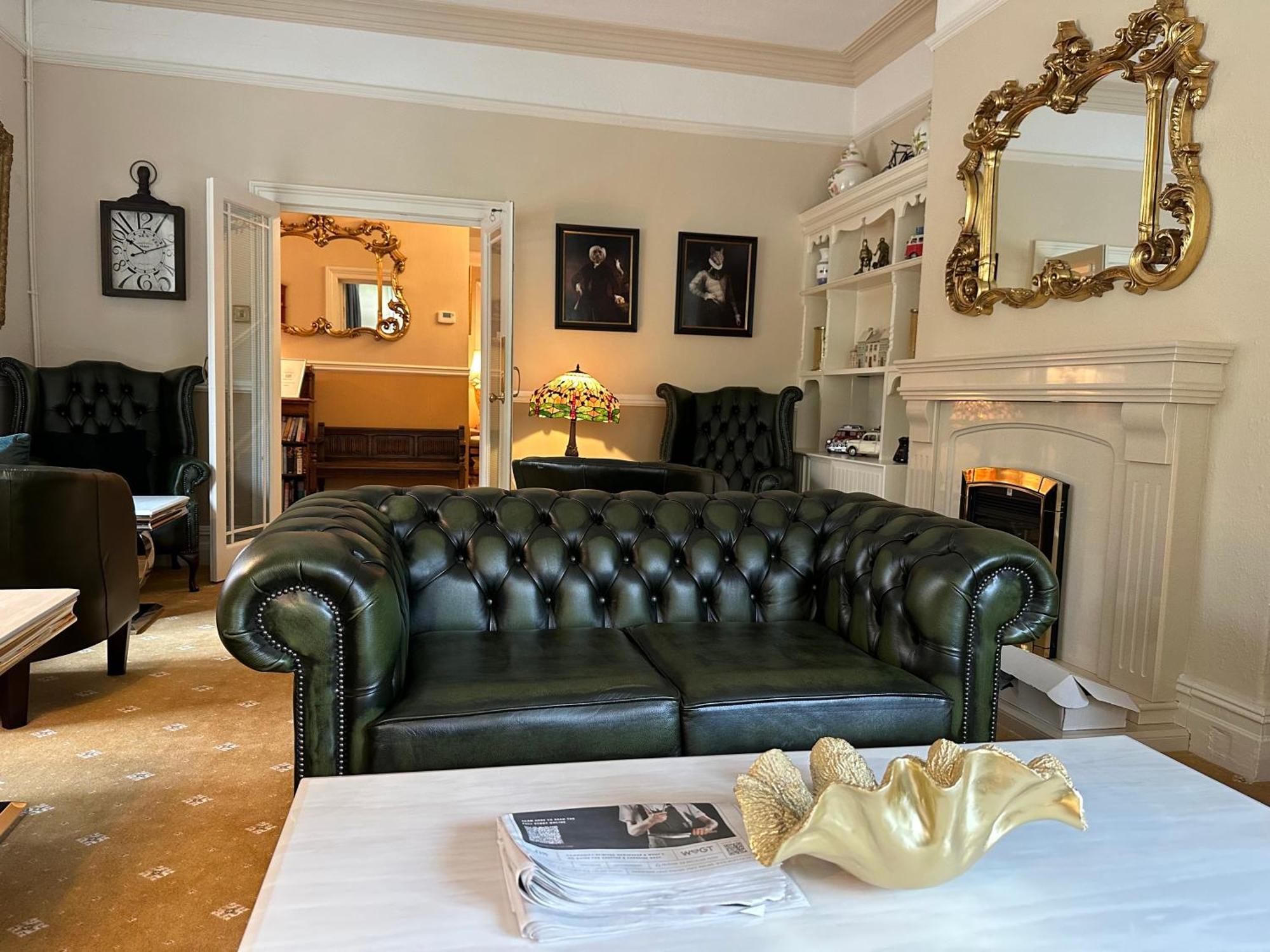 Chester House Guest House Exteriér fotografie A green leather Chesterfield sofa